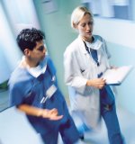 Picture of a female Doctor and a male Nurse walking down a hallway